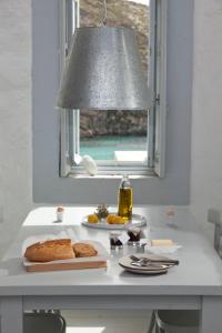 a table with a plate of bread and a window at Coco-Mat Eco Residences Serifos in Vayiá