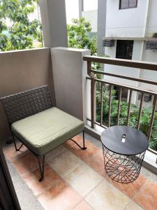 a bench and a table on a balcony at condo-living at its best in Manila