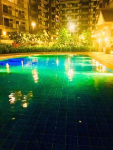 a swimming pool at night with people in it at condo-living at its best in Manila