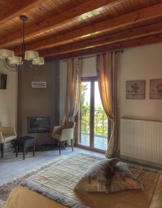 a bedroom with a large bed and a large window at Xenonas Vasilikou in Valtessiniko