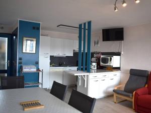 a kitchen with white cabinets and a table with chairs at Appartement Font-Romeu-Odeillo-Via, 4 pièces, 8 personnes - FR-1-580-28 in Font-Romeu-Odeillo-Via