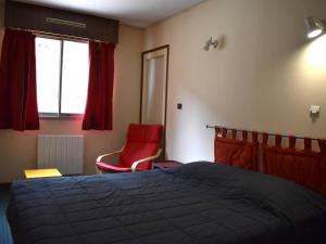 - une chambre avec un lit et une chaise rouge dans l'établissement Appartement Font-Romeu-Odeillo-Via, 4 pièces, 8 personnes - FR-1-580-28, à Font-Romeu-Odeillo-Via