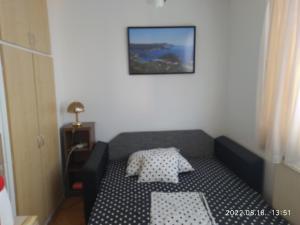ein kleines Bett in einem Zimmer mit einem Bild an der Wand in der Unterkunft 3 hippos apartman in Budapest