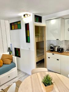 un soggiorno con tavolo e una cucina con vetrate colorate di Charmant appartement rénové 4 couchages Arcachon centre ad Arcachon