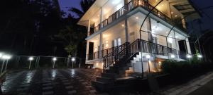 RamakkalmeduShawn Dale Homestay的夜间侧面有灯光的建筑物