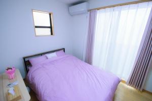 um quarto com uma cama rosa e uma janela em 615-13 Higashiboricho, which descends from Kamicho - Vacation STAY 83236 em Quioto