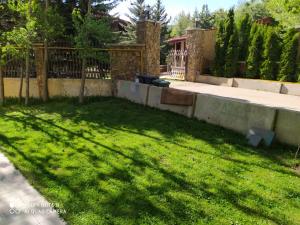 a backyard with a fence and a grass yard at ГудиВуди in Tsaghkadzor