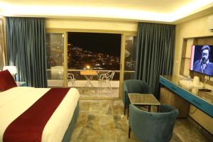 a hotel room with a bed and a view of a city at Petra Sella Hotel in Wadi Musa