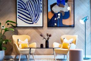 uma sala de estar com cadeiras, uma mesa e pinturas em Staycity Aparthotels Dublin City Centre em Dublin