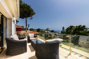 a patio with wicker chairs and a view of the ocean at 2550 Lichtdurchflutete Villa in Santa Ponsa Nova in Santa Ponsa