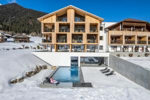 Hotel Tyrol في فالي دي كاسيس: مبنى فيه مسبح في الثلج