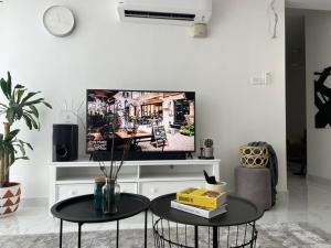 a living room with two tables and a flat screen tv at The Penthouse TROIKA KOTA BHARU in Kota Bharu