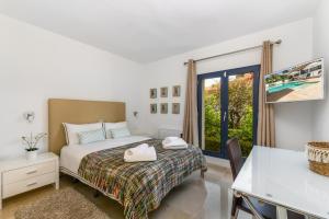 a bedroom with a bed and a desk and a window at 2550 Lichtdurchflutete Villa in Santa Ponsa Nova in Santa Ponsa