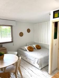 una camera da letto bianca con un letto e un tavolo di Charmant appartement rénové 4 couchages Arcachon centre ad Arcachon