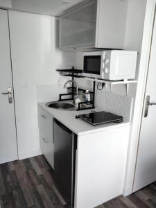 a small kitchen with a sink and a microwave at Studio indépendant in Fouras