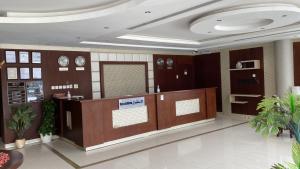 a lobby with a reception desk and clocks on the wall at Capital residence in Riyadh