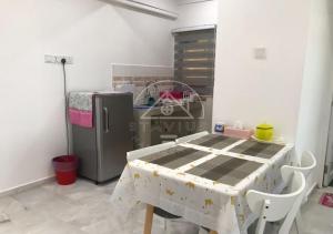 una sala da pranzo con tavolo e frigorifero di Cozy Apartment 2BR 5pax Glory Beach Resort a Port Dickson