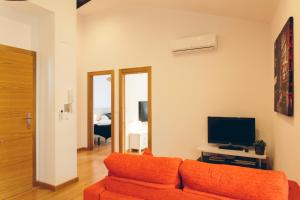 een woonkamer met een bank en een televisie bij The Lucky Flats - Artilleros in Alicante