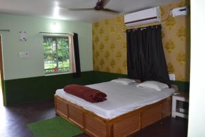 1 dormitorio con 1 cama con sábanas blancas y ventana en Kanikasundari Home Stay, en Bālianta
