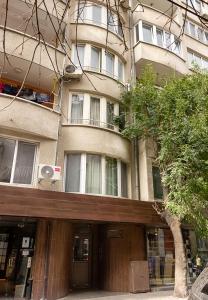 un bâtiment avec un arbre en face dans l'établissement ~ The Blue Apartment ~ 1BD with a Cozy Balcony, à Varna