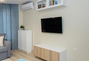 - un salon avec un canapé et une télévision murale dans l'établissement ~ The Blue Apartment ~ 1BD with a Cozy Balcony, à Varna
