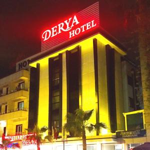 a hotel with a neon sign on top of it at Derya Hotel in Mersin