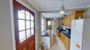 cocina con nevera blanca y ventana en Cambridge House en Sidmouth