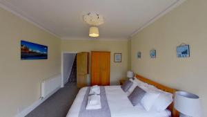 1 dormitorio con 1 cama grande con sábanas blancas en Cambridge House en Sidmouth