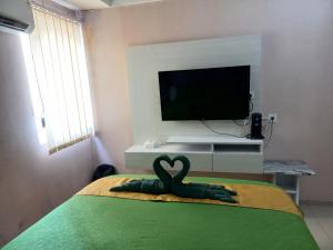 a bedroom with a bed with a swan decoration on it at Nature's Room @ Aeropolis in Rawabambu
