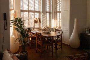 ein Esszimmer mit einem Tisch, Stühlen und Fenstern in der Unterkunft Babette Guldsmeden in Kopenhagen