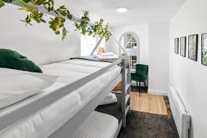 1 dormitorio con 2 camas y silla verde en The Treehouse at The Hideaway STAMP SA, en Blackpool