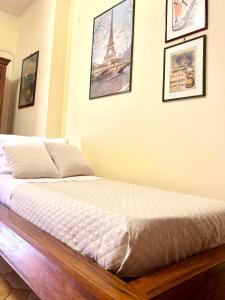 - un lit dans un dortoir avec des photos sur le mur dans l'établissement casadifederica, à Palerme