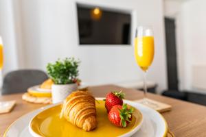 a plate of croissants and strawberries and a glass of orange juice at The Snug at The Hideaway STAMP SA in Blackpool