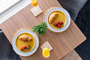 two bowls of soup with croissants and strawberries on a table at The Snug at The Hideaway STAMP SA in Blackpool