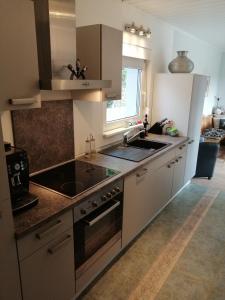 a kitchen with a sink and a stove top oven at Komfortabler Bungalow, Husen 15 , 2 bis 4 Personen, Europa-Feriendorf in Husen