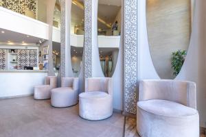 - un hall avec des chaises blanches et un escalier dans l'établissement Agripas Boutique Hotel, à Jérusalem