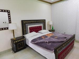 1 dormitorio con 1 cama grande y 2 mesitas de noche en Bhurban View Apartments, en Murree