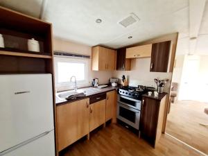 Kuchyň nebo kuchyňský kout v ubytování 10 Berth Caravan For Hire At Seawick Holiday Park In Essex Ref 27102sw