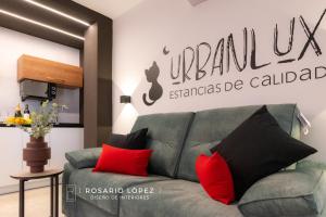 a living room with a green couch and red pillows at Urbanlux Olimpia Sleep & More in Albacete