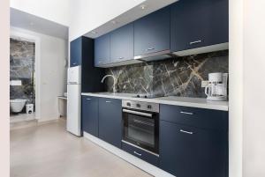 a kitchen with navy blue cabinets and a stove at TheJoy Residence Apartments in Chania