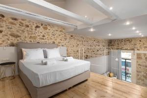 una camera con un grande letto e un muro di mattoni di TheJoy Residence Apartments a Chania