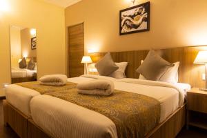 a hotel room with two beds with pillows on them at Starlit Suites Tirupati LLP in Tirupati