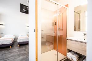 La salle de bains est pourvue d'une douche et d'un lavabo. dans l'établissement Hôtel PB - Paris-Barcelone, à Perpignan