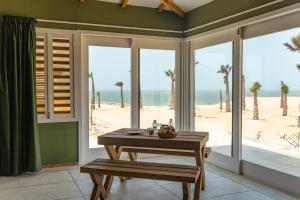 a dining room with a table and a view of the beach at Oasis212 Dakhla in Dakhla