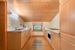 a kitchen with wooden ceilings and a wooden floor at Ferienwohnung Spielberg in Sankt Martin bei Lofer