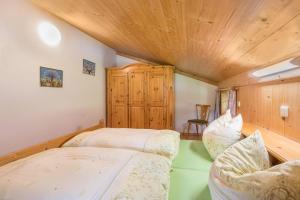 sypialnia z 2 łóżkami i drewnianym sufitem w obiekcie Ferienwohnung Spielberg w mieście Sankt Martin bei Lofer