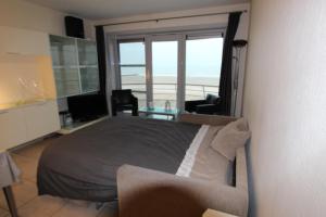 a bedroom with a bed and a view of the ocean at Appartement Zeezicht in Ostend