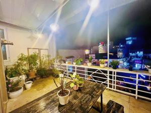 a room with a table and potted plants on a balcony at HÙNG Apartment Dalat in Da Lat