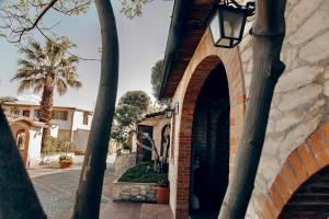 um edifício de tijolos com uma porta e uma palmeira em Agriturismo Posta Guevara em Castelluccio dei Sauri