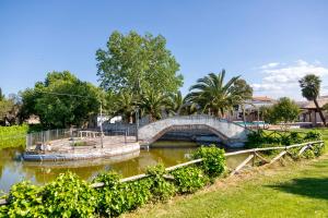 un puente sobre un río en un parque en Agriturismo Posta Guevara, en Castelluccio dei Sauri